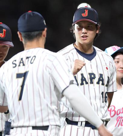 試合前セレモニーで佐藤輝（手前）とグータッチする大谷＝２７日
