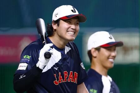 　打撃練習中に笑顔を見せる大谷。右は吉田