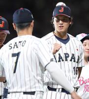 試合前セレモニーで佐藤輝（手前）とグータッチする大谷＝２７日