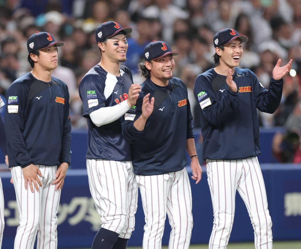 中日に勝利し、笑顔でナインを迎える佐藤輝（左）