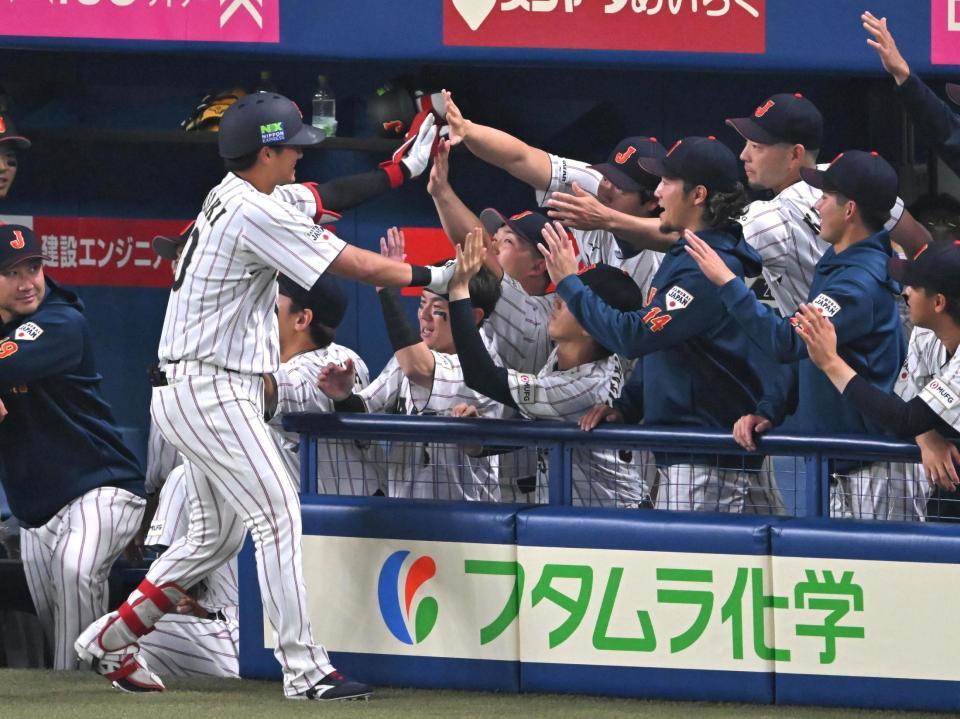 ２回、ソロを放ちナインとタッチを交わす佐々木（撮影・飯室逸平）