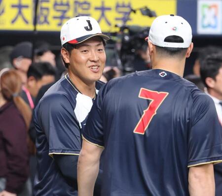 佐藤（右）と談笑する岡本