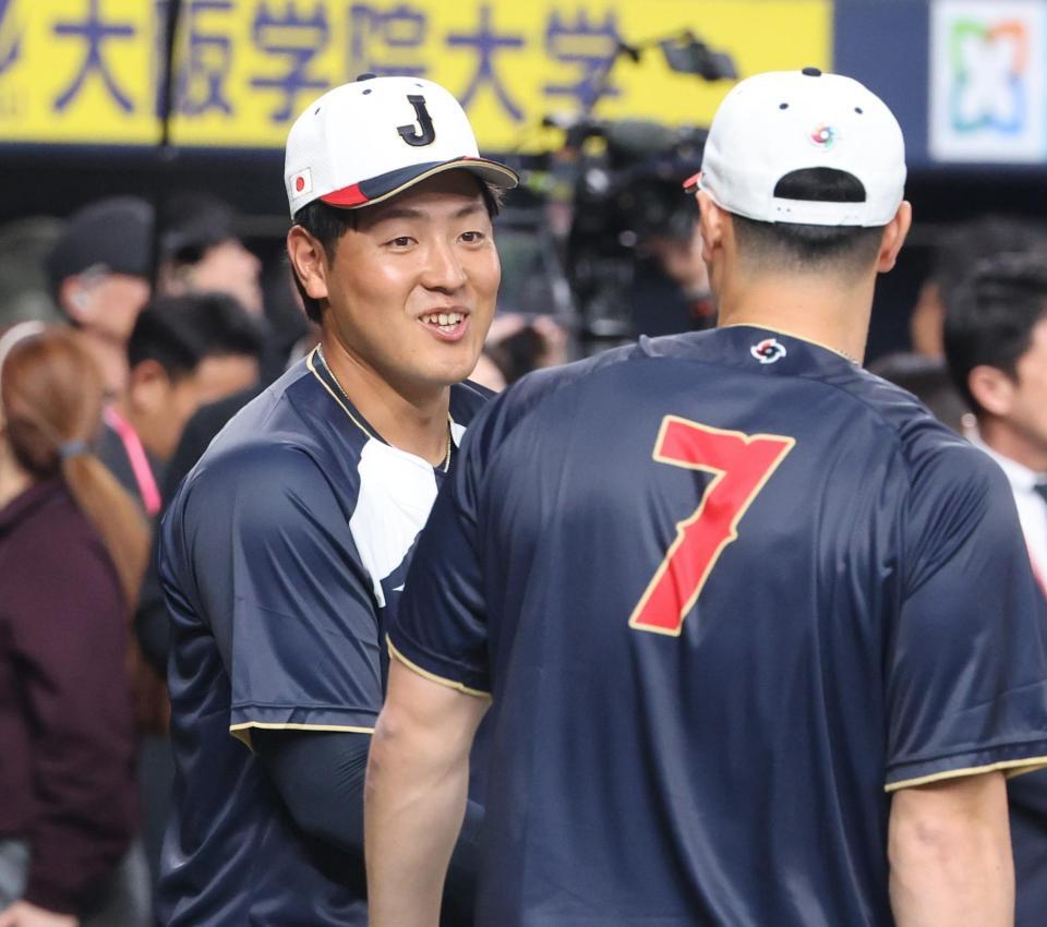 佐藤（右）と談笑する岡本