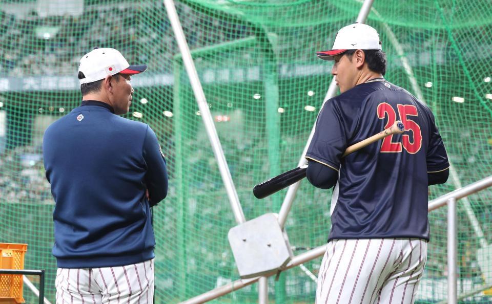 井端監督（左）と話す岡本（撮影・中田匡峻）
