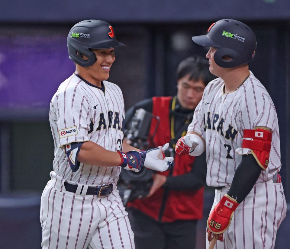 ５回、ライトへソロを放ち、牧（右）と笑顔でタッチを交わす吉田（撮影・中田匡峻）