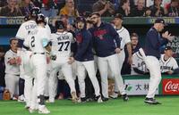 先制の中犠飛を放ったメンシク（７７番）を出迎えるナイン（撮影・佐々木彰尚）