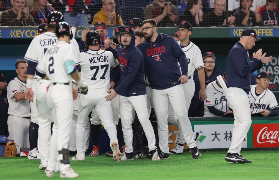 先制の中犠飛を放ったメンシク（７７番）を出迎えるナイン（撮影・佐々木彰尚）