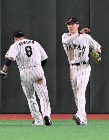 ９回、韓国・ジョーンズの打球を好捕し、近藤とタッチを交わす周東