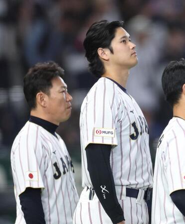 国歌斉唱で国旗を見つめる大谷（右）と井端監督（撮影・伊藤笙子）