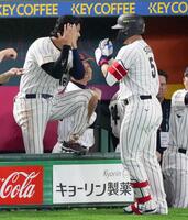 　３回、２打席連続の本塁打を放ち、ベンチで大谷（左）に迎えられる鈴木