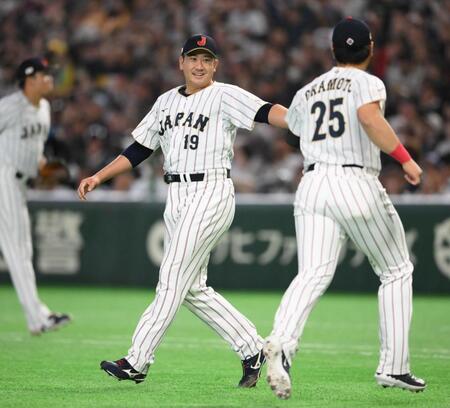 ３回を投げ終えて岡本（右）とタッチを交わす菅野（撮影・堀内翔）