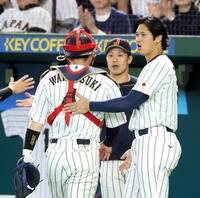 ６回表を終え、ベンチへ戻る捕手若月（左）を迎える大谷