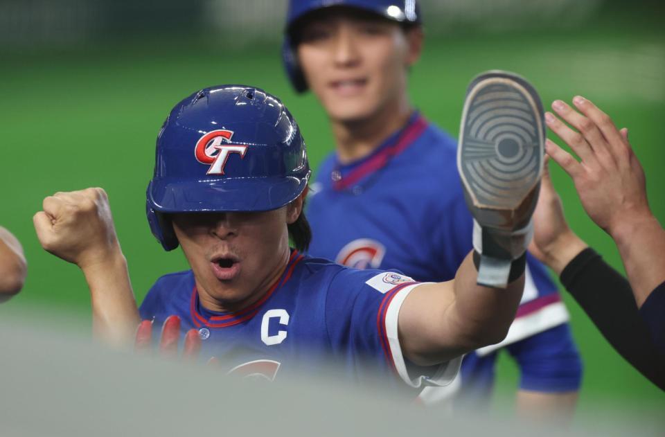 延長１０回、スクイズで決勝の生還しナインに迎えられる台湾・陳傑憲（撮影・金田祐二）