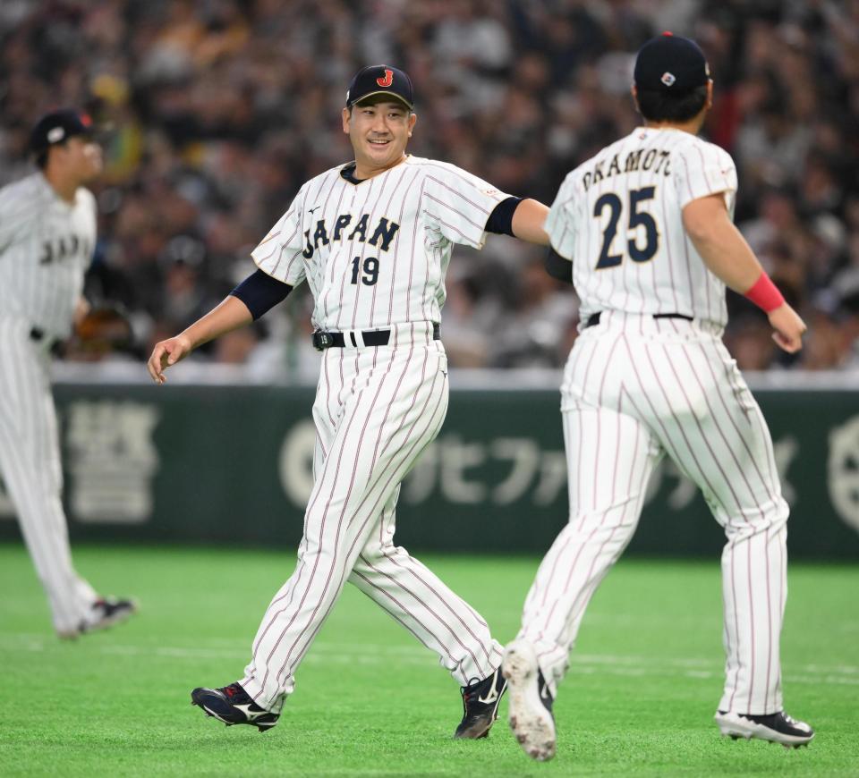 ３回を投げ終えて岡本（右）とタッチを交わす菅野（撮影・堀内翔）