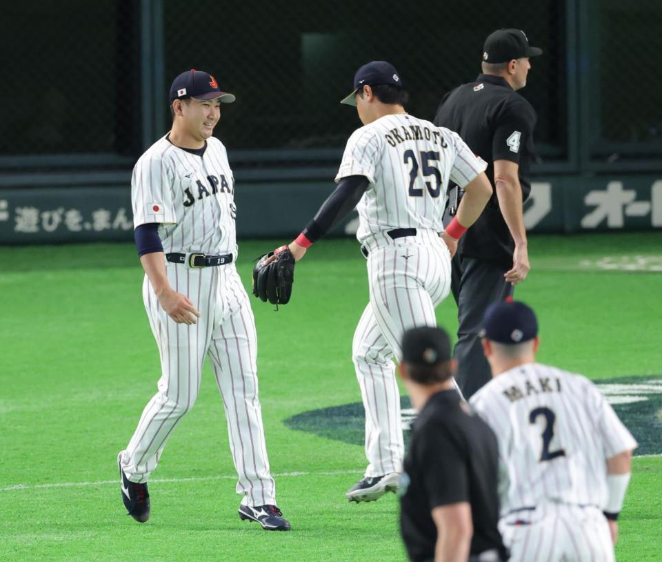 ３回を無失点に抑え、岡本とタッチを交わす菅野（撮影・西岡正）