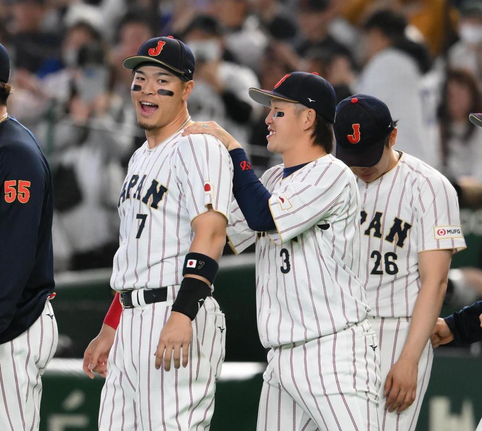 ９回、勝利を決めて小園（右）に肩をもまれる佐藤輝（撮影・堀内翔）