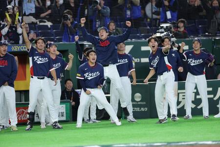 ９回、安賢民の犠飛でベンチを飛び出す韓国ナイン（撮影・西岡正）