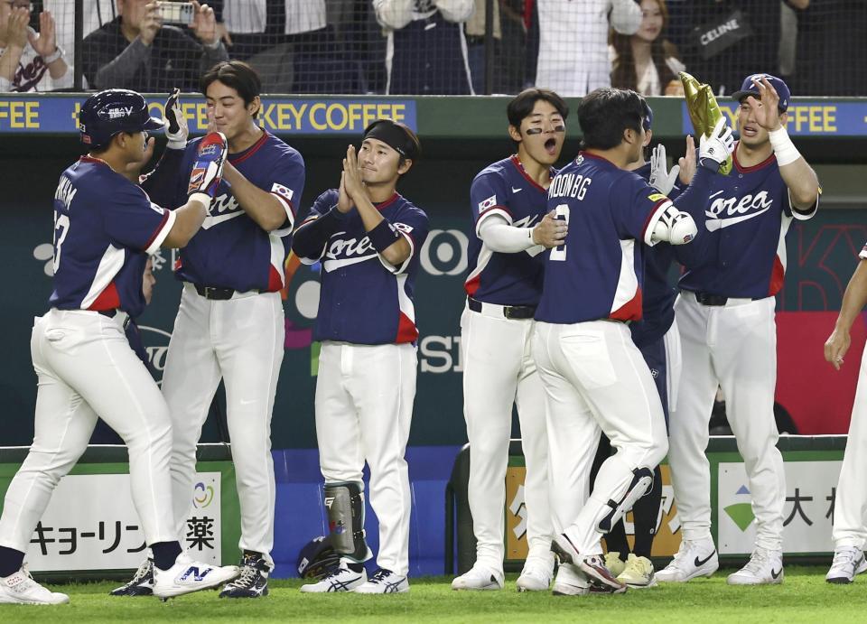 ２回、先制２ランを放った文保景（右から２人目）をベンチで迎える韓国の選手たち