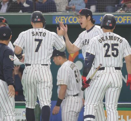 １回、二塁打を放った佐藤輝（左）とタッチを交わす大谷（撮影・西岡正）