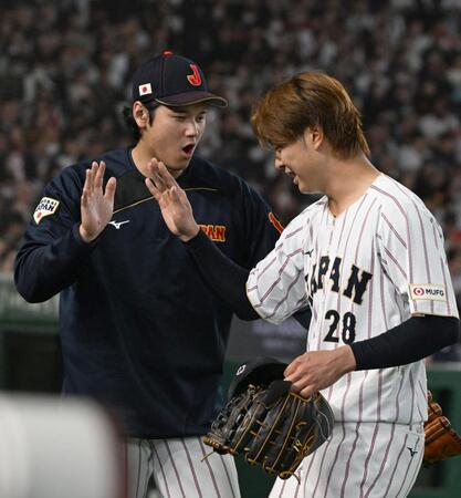 ５回１死、チェコのチェルベンカを右飛に打ち取って降板する高橋を出迎える大谷（左）