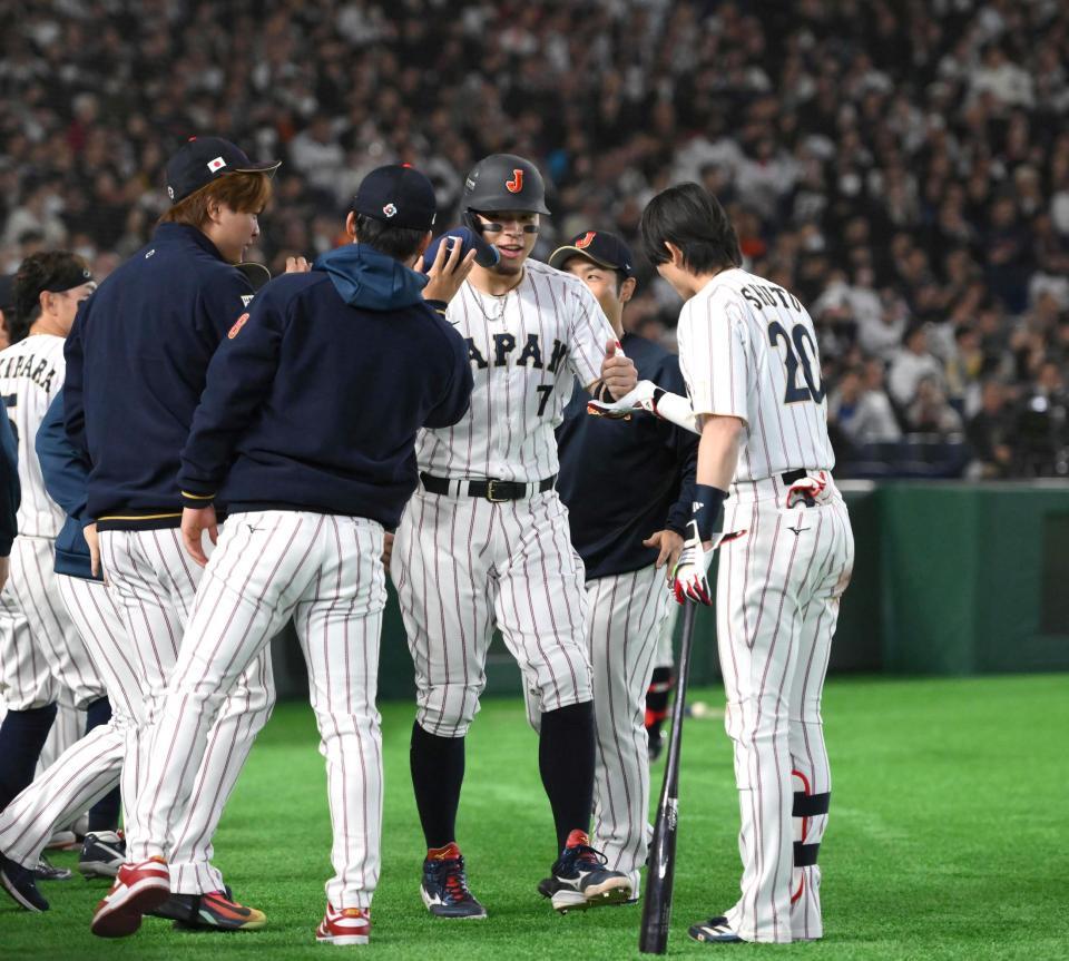 ８回、生還してタッチを交わす佐藤輝（中央）＝撮影・堀内翔