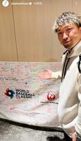 　寄せ書きの前でポーズをとる鈴木。大谷翔平のインスタグラム（ｓｈｏｈｅｉｏｈｔａｎｉ）より
