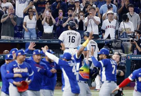 　９回、遊飛に倒れて最後の打者となった大谷（16）。手前は日本に勝利し喜ぶベネズエラの選手たち（共同）
