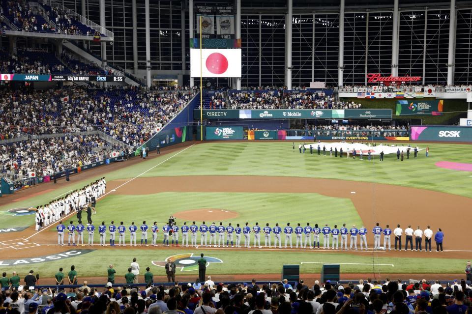 　試合前のセレモニーで整列する両チームの選手たち（共同）