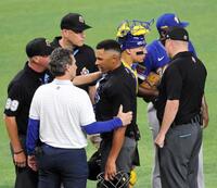 　他の審判員、スタッフから状態を確認されるリハック球審（中央）＝撮影・伊藤笙子