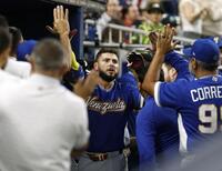 　米国戦の５回、本塁打を放ちタッチを交わすベネズエラのアブレイユ＝マイアミ（共同）