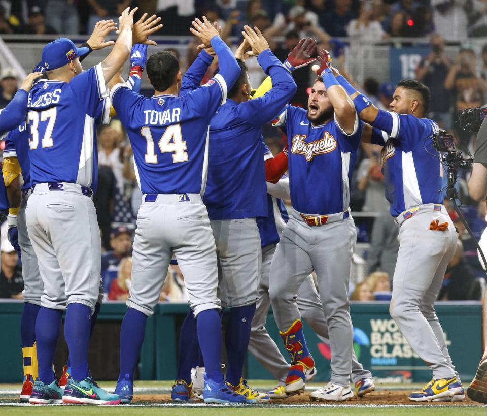 　米国戦の５回、本塁打を放ち迎えられるベネズエラのアブレイユ（右から２人目）＝マイアミ（共同）