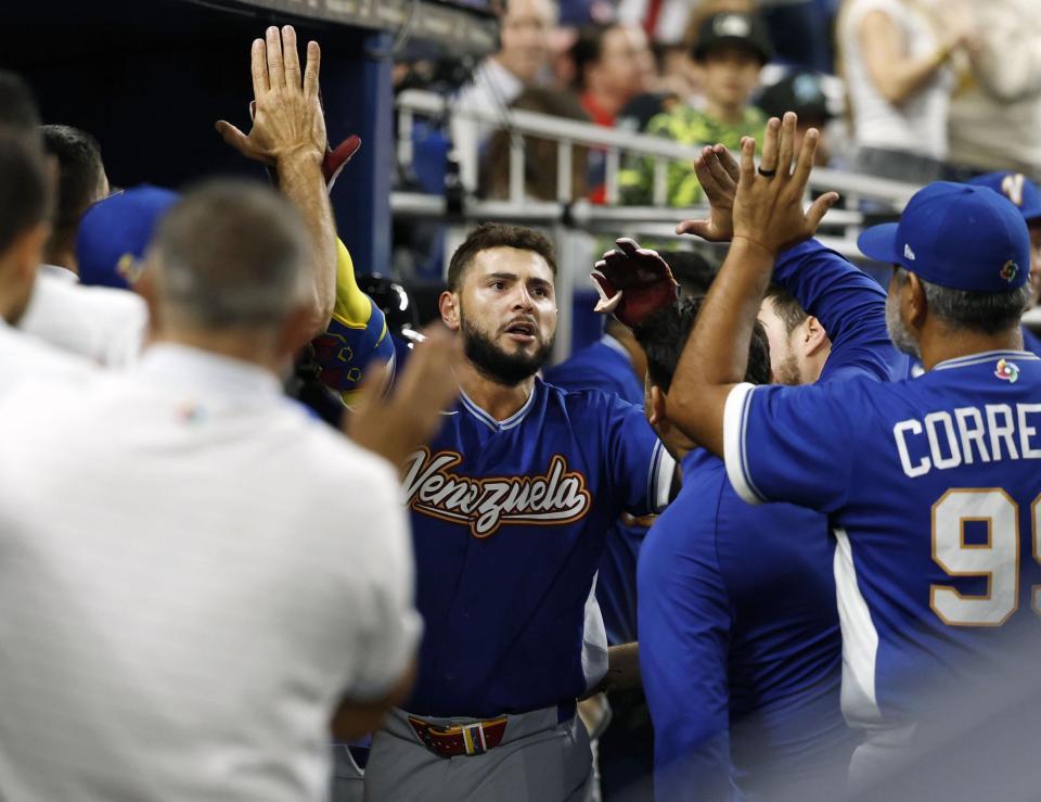 　米国戦の５回、本塁打を放ちタッチを交わすベネズエラのアブレイユ＝マイアミ（共同）