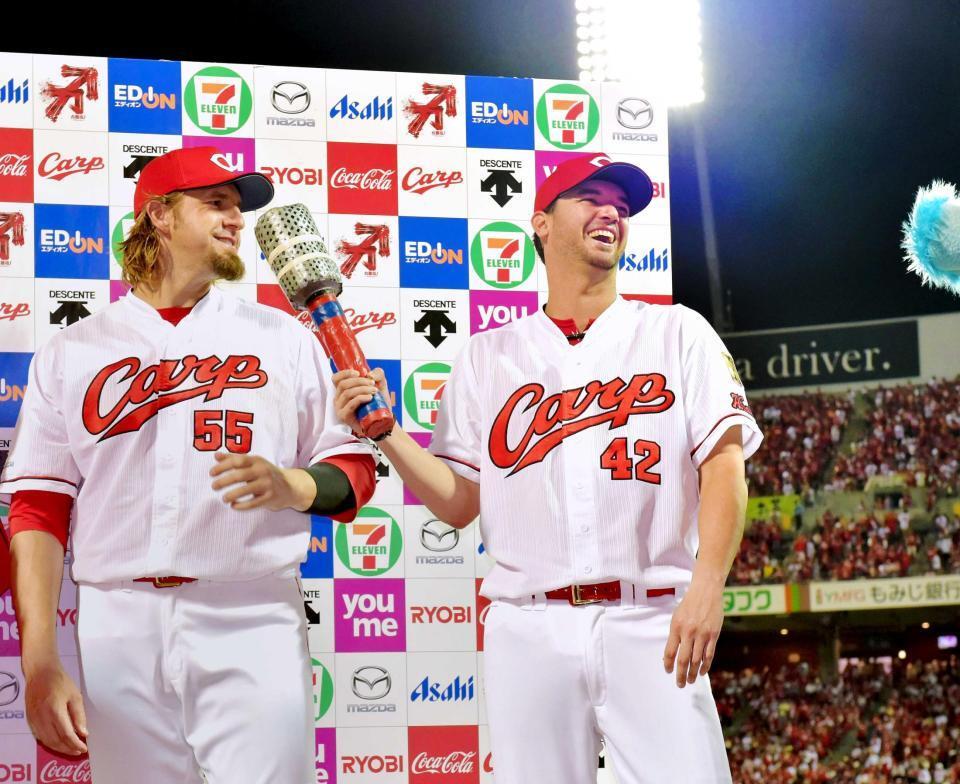 　８月２５日の中日戦で８回無失点の好投で５勝目を挙げたジョンソン（右）はエルドレッド（左）に巨大マイクを向けて笑顔を見せる（撮影・吉澤敬太）