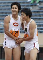 　男子１００メートル決勝を終え、健闘をたたえ合う優勝の山県亮太（右）と２位の飯塚翔太