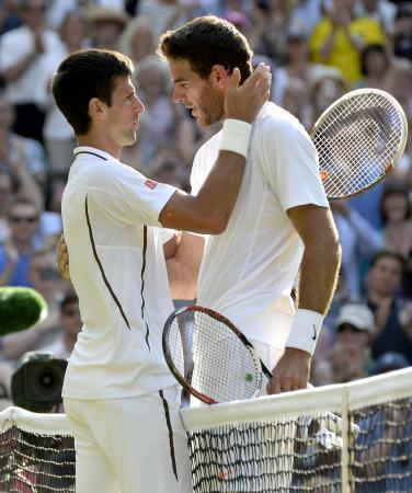 　男子シングルス準決勝でフアンマルティン・デルポトロ（右）を接戦の末に破り、健闘をたたえるノバク・ジョコビッチ＝ウィンブルドン（共同）