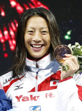 　女子１００メートル背泳ぎで銅メダルを獲得し、表彰台で笑顔の寺川綾（共同）