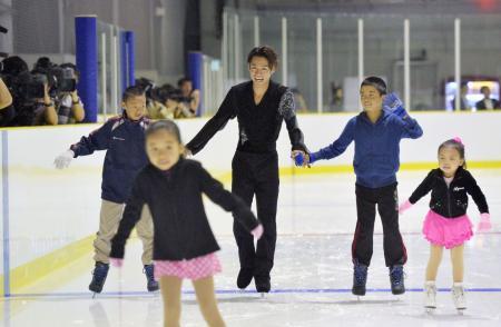 　「ひょうご西宮アイスアリーナ」のオープン式典で、地元の小学生と一緒に滑るフィギュアスケートの高橋大輔選手（中央）＝２日午後、兵庫県西宮市