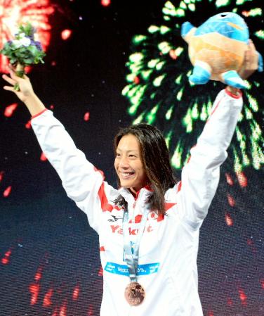 　女子50メートル背泳ぎで銅メダルを獲得し、表彰式で歓声に応える寺川綾＝バルセロナ（共同）
