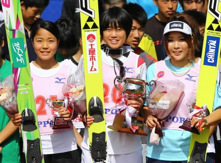 　表彰式で笑顔を見せる、優勝した伊藤有希（中）、２位の高梨沙羅（左）、３位の茂野美咲
