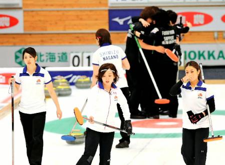 　中部電力を破り抱き合って喜ぶ北海道銀行の選手（後方）と、うなだれる中部電力の（右から）市川、藤沢、松村ら＝どうぎんカーリングスタジアム