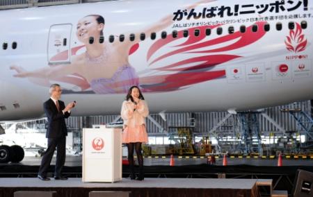 自分の巨大写真が塗装されたデカール２号機を見て驚く浅田真央（中央）左はＪＡＬ執行役員兼東京空港支店長の篠原敏夫氏＝東京・羽田空港ＪＡＬＭ２格納庫（撮影・開出　牧）