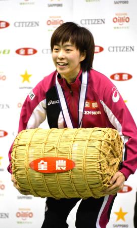 　女子シングルスで優勝し、副賞の米俵を抱え笑顔の石川佳純（撮影・岩崎拓郎）