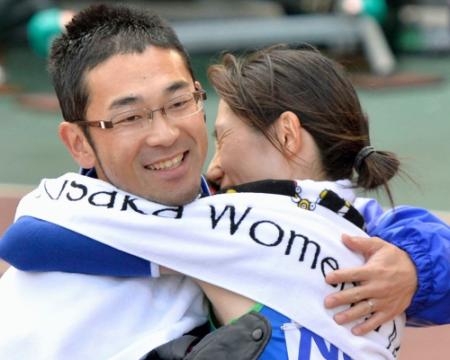 引退レースの大阪国際女子マラソンで、日本勢最高の２位に入り、夫の周平コーチと抱き合う赤羽有紀子選手＝26日、大阪市の長居陸上競技場