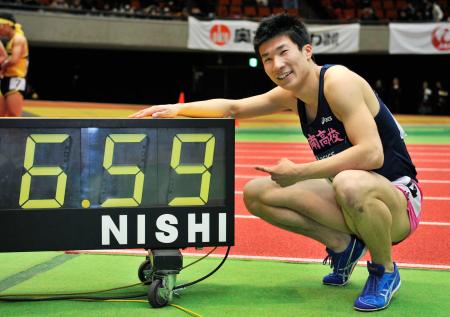 　６秒５９が表示された掲示板の前でポーズをとる、男子６０メートルで優勝した桐生祥秀