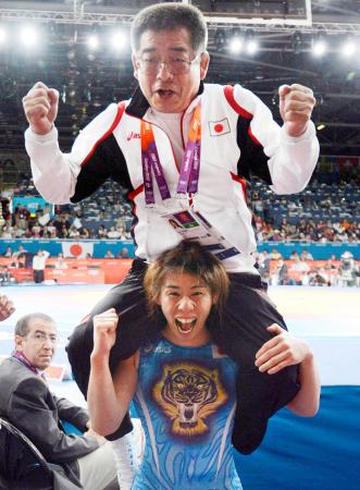 　ロンドン五輪のレスリング女子５５キロ級で３連覇を達成し、父栄勝コーチ（上）を肩車して喜ぶ吉田沙保里＝２０１２年８月（共同）