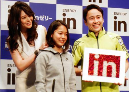 　高梨沙羅（中央）は、知花くらら（左）からネックレスをつけてもらい笑顔。右はフェンシングの太田雄貴