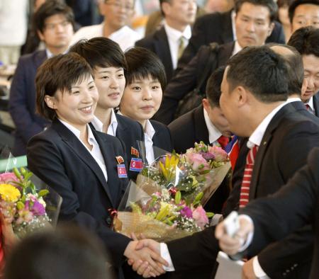 　卓球の世界選手権団体戦出場のため来日し、朝鮮総連関係者らの歓迎を受ける北朝鮮の選手ら＝２６日午後、成田空港