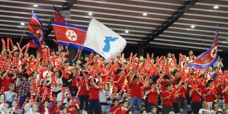 　世界卓球団体で北朝鮮と韓国が対戦し、国旗や統一旗を手に声援を送る北朝鮮の応援席＝１日、東京・国立代々木競技場
