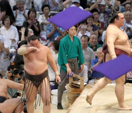 　稀勢の里（右）に敗れ、座布団が舞う中土俵下で悔しがる白鵬