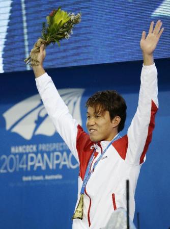 　男子１００メートル平泳ぎで優勝し、表彰式で声援に応える小関也朱篤